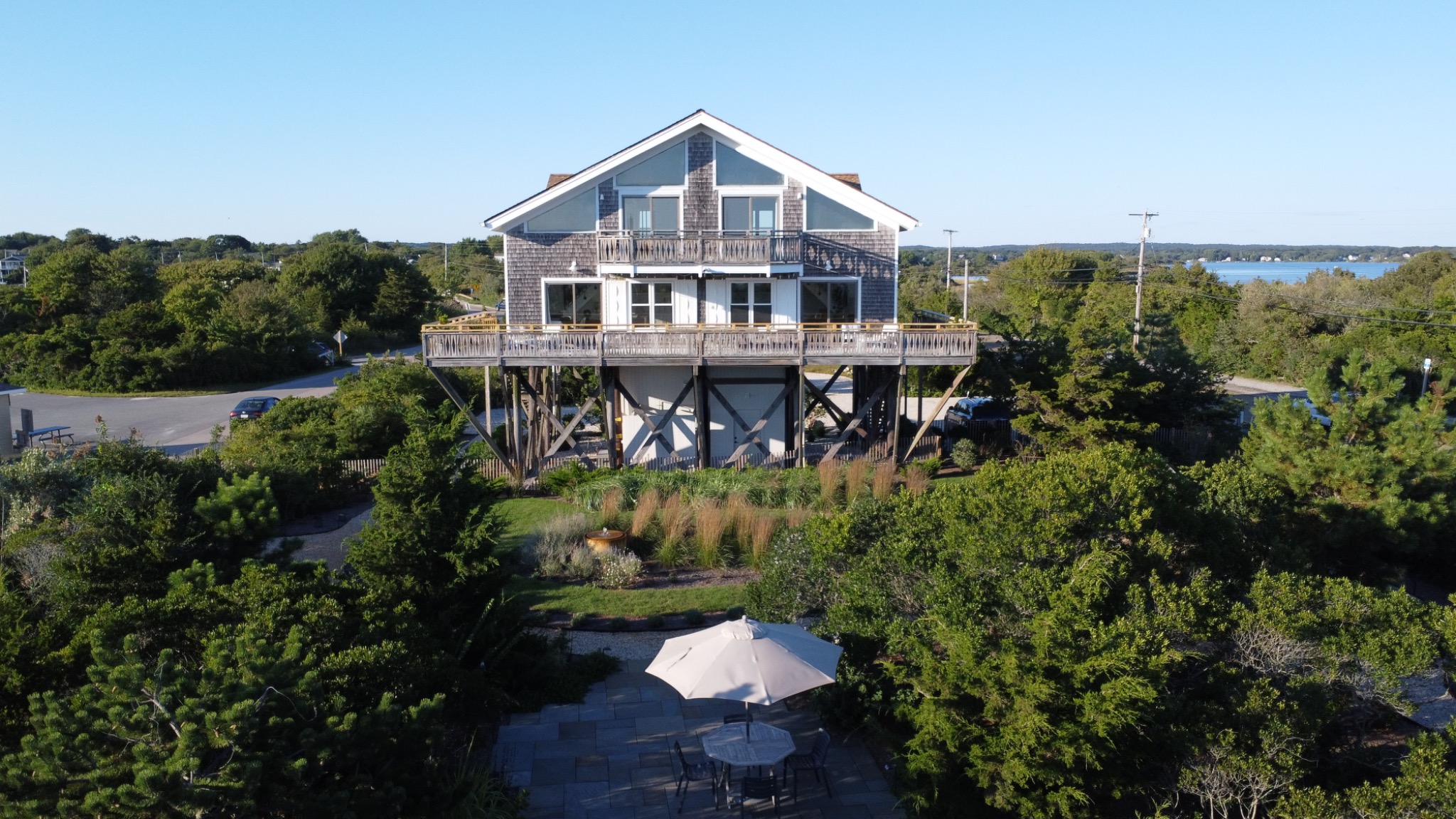 Surf House rising above the gardens, with the patio in the foreground and the salt pond beyond.